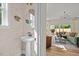 Stylish powder room with pedestal sink, decorative mirror, and view into the open living room at 215 Faith Avenue, Sanford, NC 27330