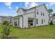Well-maintained backyard featuring a covered patio, lush lawn, and charming home exterior at 215 Faith Avenue, Sanford, NC 27330