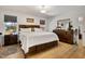 Spacious bedroom with hardwood floors, a large bed, dresser, and ample natural light from the windows at 2302 Fordcrest Dr, Apex, NC 27502