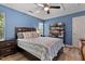 Well-lit bedroom with blue walls, ceiling fan, and a comfortable-looking bed at 2302 Fordcrest Dr, Apex, NC 27502