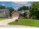 Charming brick home with a two-car garage, manicured lawn, and mature trees creating a welcoming curb appeal at 2302 Fordcrest Dr, Apex, NC 27502