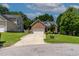 Charming brick home with a two-car garage, manicured lawn, and mature trees creating a welcoming curb appeal at 2302 Fordcrest Dr, Apex, NC 27502