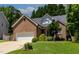 Close up of charming brick home with manicured lawn and beautiful front yard landscaping at 2302 Fordcrest Dr, Apex, NC 27502
