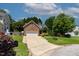 Charming brick home with a two-car garage, manicured lawn, and mature trees creating a welcoming curb appeal at 2302 Fordcrest Dr, Apex, NC 27502