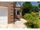 Classic front door with white trim and brick steps, surrounded by lush landscaping at 2302 Fordcrest Dr, Apex, NC 27502