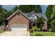 Charming brick home featuring manicured lawn, attached garage, and classic architectural details at 2302 Fordcrest Dr, Apex, NC 27502