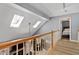 Bright hallway with wood floors, skylights, and an open view to the lower level at 2302 Fordcrest Dr, Apex, NC 27502