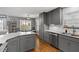 Updated kitchen features gray cabinets, stainless appliances, granite countertops, and breakfast bar at 2302 Fordcrest Dr, Apex, NC 27502