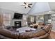 Open-concept living room with fireplace and leather sectional, with adjacent kitchen and breakfast areas at 2302 Fordcrest Dr, Apex, NC 27502