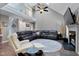 Spacious living room features a fireplace, vaulted ceiling, and an oversized leather sectional sofa at 2302 Fordcrest Dr, Apex, NC 27502