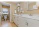 Bright bathroom featuring double sinks, white cabinets, and tile flooring at 240 Oak Grove Church Rd, Youngsville, NC 27596