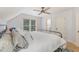 Neutral bedroom with light walls, a ceiling fan, and a window that looks out onto trees at 240 Oak Grove Church Rd, Youngsville, NC 27596