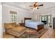 Comfortable main bedroom featuring a ceiling fan, wood floors, and an attached sunroom overlooking trees at 240 Oak Grove Church Rd, Youngsville, NC 27596