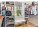 Well-lit walk-in closet featuring built-in shelves, a bench, and a window at 240 Oak Grove Church Rd, Youngsville, NC 27596
