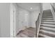 Hallway with wooden staircase, white doors, and laminate flooring that creates a clean and bright aesthetic at 2539 Kasota Ln, Raleigh, NC 27610