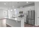Modern kitchen with stainless steel appliances, white cabinets, and a center island with seating and ample countertop space at 2539 Kasota Ln, Raleigh, NC 27610