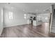 Open concept floor plan with kitchen and staircase, featuring hardwood floors and white cabinets at 2539 Kasota Ln, Raleigh, NC 27610