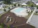 Aerial view of a community pool and playground with nearby neighborhood homes and streetscape at 2613 Red Spruce Dr, Raleigh, NC 27616