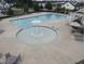 A community pool includes a splashpad and multiple seating areas for relaxing at 2613 Red Spruce Dr, Raleigh, NC 27616