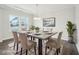 Bright dining room with a modern table set, decorative lighting, and a large window overlooking the neighborhood at 2613 Red Spruce Dr, Raleigh, NC 27616