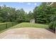 A large backyard with mature trees, a storage shed, and a concrete patio at 2904 Britmass Dr, Raleigh, NC 27616