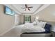 Bright bedroom features tray ceilings, ceiling fan and a large bed with white comforter and decorative pillows at 2904 Britmass Dr, Raleigh, NC 27616