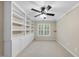 Bedroom with built-in shelves, a ceiling fan, carpeted floors, and a window with shutters at 2904 Britmass Dr, Raleigh, NC 27616