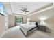 Spacious bedroom featuring a tray ceiling, ceiling fan and a large window at 2904 Britmass Dr, Raleigh, NC 27616