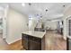 Open kitchen with granite counters leading to living room with fireplace and stairs at 2904 Britmass Dr, Raleigh, NC 27616
