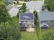 A tan two-story home's rear exterior featuring solar panels, a covered patio, and a well-maintained backyard at 2904 Britmass Dr, Raleigh, NC 27616