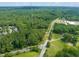 An aerial view displays the community nestled among lush green trees, with a tall communication tower nearby at 3006 Pump Station Ln, Durham, NC 27712