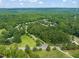 Expansive aerial view of a community nestled among lush green trees and landscaping on a bright sunny day at 3006 Pump Station Ln, Durham, NC 27712
