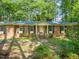 Inviting brick home featuring a classic front porch with columns and dark shutters against the windows at 3006 Pump Station Ln, Durham, NC 27712