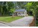 Exterior view of charming home with green lawn, gravel driveway, and mature trees at 308 Greenwood Dr, Durham, NC 27704