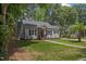 Charming home with mature trees, green lawn, dark shutters, and attractive landscaping at 308 Greenwood Dr, Durham, NC 27704