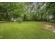 Lush green backyard surrounded by mature trees, offering privacy and space at 313 Teresa Dr, Rolesville, NC 27571