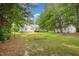 Expansive backyard showcasing the home, deck, garage, and mature trees at 313 Teresa Dr, Rolesville, NC 27571