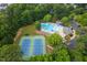 Aerial view of tennis courts and a pool surrounded by trees in a neighborhood complex at 317 Chanticlair Dr, Apex, NC 27502