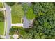 Aerial view of a gray roofed house surrounded by lush greenery with a well manicured lawn and long driveway at 317 Chanticlair Dr, Apex, NC 27502