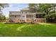 Grassy backyard and gray home featuring a large deck with seating, dining and grilling spaces at 317 Chanticlair Dr, Apex, NC 27502