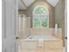 The bathroom features a large tub with jets, a standing shower and a floral wallpaper at 317 Chanticlair Dr, Apex, NC 27502
