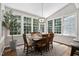 Sunlit dining area featuring a table, chairs and large windows with a view to the outdoors at 317 Chanticlair Dr, Apex, NC 27502