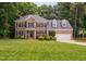 Beautiful two-story brick home with a well-manicured lawn and mature landscaping at 317 Chanticlair Dr, Apex, NC 27502