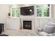 Beautiful fireplace with built-in cabinets and shelving, topped with a large flatscreen TV at 317 Chanticlair Dr, Apex, NC 27502