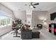 Finished bonus room includes a large gray sectional couch, a ceiling fan and an arcade game at 317 Chanticlair Dr, Apex, NC 27502