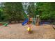 A well-maintained playground features a blue slide and ride-on toys in a wood-chip ground cover at 317 Chanticlair Dr, Apex, NC 27502