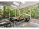 Covered, screened porch features a ceiling fan, skylights, and outdoor seating with views of the lush backyard at 317 Chanticlair Dr, Apex, NC 27502