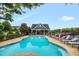 A community pool features lounge chairs, a bath house, and a clear blue pool for neighborhood enjoyment at 326 Hope Valley Rd, Knightdale, NC 27545
