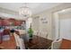 Chic dining area features a chandelier and wood table, with an open view of the kitchen at 326 Hope Valley Rd, Knightdale, NC 27545