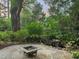 Beautiful backyard oasis featuring a stone patio with a fire pit, a waterfall, and lush landscaping, perfect for outdoor gatherings at 3324 Thomas Rd, Raleigh, NC 27607